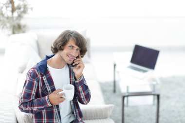 güzel bir fincan adamla bir dizüstü bilgisayar önünde oturur.