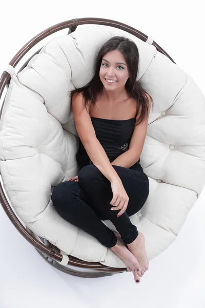 Sorrindo jovem mulher descansando em grande poltrona macia — Fotografia de Stock