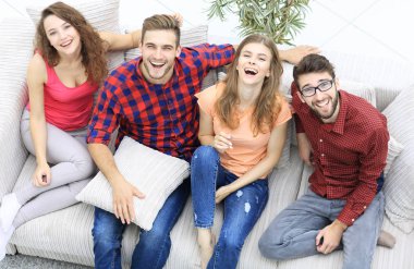 dört mutlu arkadaş kanepede otururken gülüyor