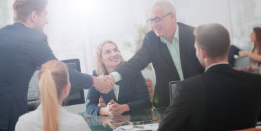 Ortağı ile bir anlaşma imzalamaya tokalaşırken olgun iş adamı