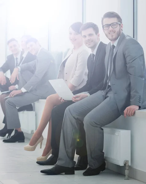 Zespół firmy siedząc na parapecie w nowym biurze — Zdjęcie stockowe