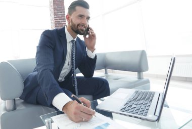 İşadamı Smartphone'da finansal belgeler hakkında konuşmak