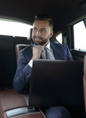 Bir arabanın arka koltuğunda oturan başarılı adam