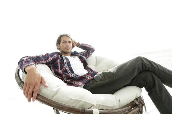 Seriös kille vilar sitter i en stor bekväm stol. sidovy. — Stockfoto