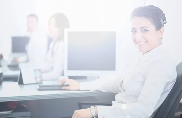 Nahaufnahme Porträt einer Geschäftsfrau, die Ihnen ein süßes Lächeln mit Kollegen im Hintergrund schenkt — Stockfoto