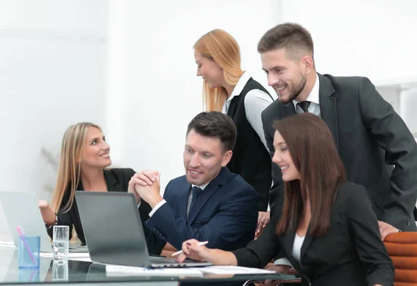 Equipe de negócios discutindo novas informações, de pé na frente do laptop aberto — Fotografia de Stock