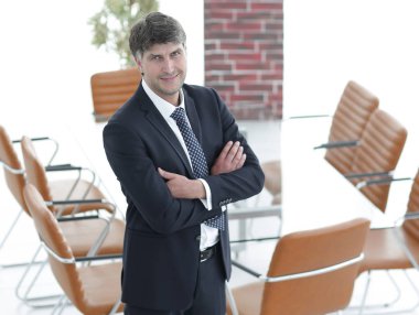 Bir boş toplantı odasında duran iş adamı