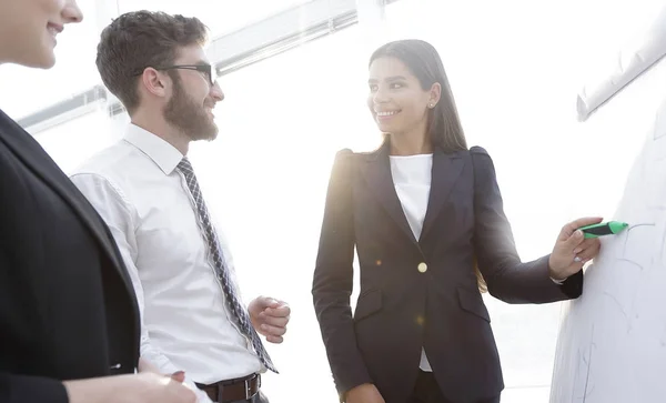 Business woman pointing with a marker on the flipchart — Stock Photo, Image