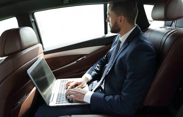 Empresario trabajando con el ordenador portátil sentado en el coche — Foto de Stock