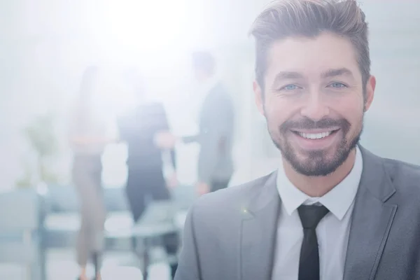 Hombre de negocios guapo en una oficina con fondo borroso — Foto de Stock