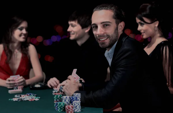 Jugadores de poker sentados alrededor de una mesa en un casino —  Fotos de Stock