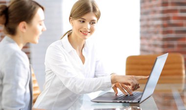 Kadın Yönetici dizüstü bilgisayardan müşteri bilgilerini gösterir..