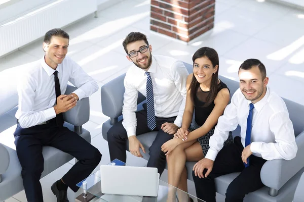 Equipe de negócios amigável sentado no lobby do escritório — Fotografia de Stock