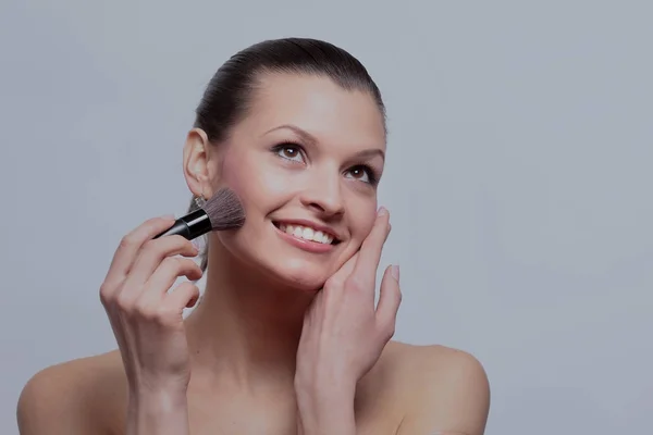 Mulher sorridente aplicar maquiagem — Fotografia de Stock