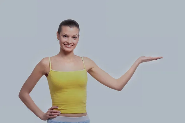 Mulher sorrindo mostrando palma da mão aberta com espaço de cópia para o produto — Fotografia de Stock