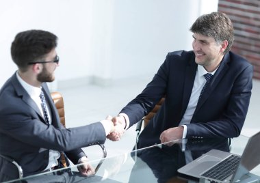 İş adamları el sıkışır, masada otururlar. .