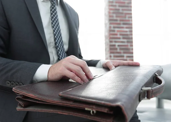 Businessmans hand med suitecase i ett modernt kontor — Stockfoto