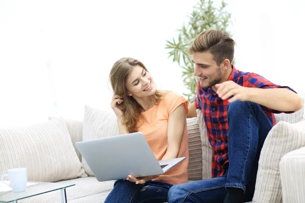 Jovem e sua namorada olhando para fotos no laptop . — Fotografia de Stock