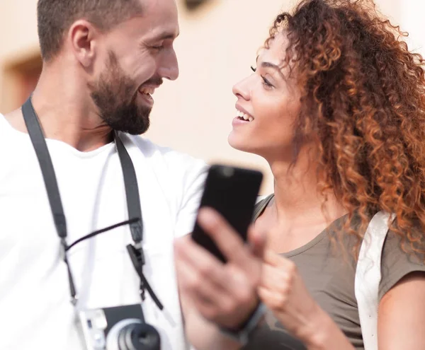 Leende par använda smart telefon tillsammans i city — Stockfoto