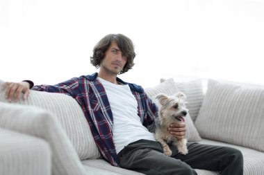 şık adam köpeğiyle kanepede oturan.