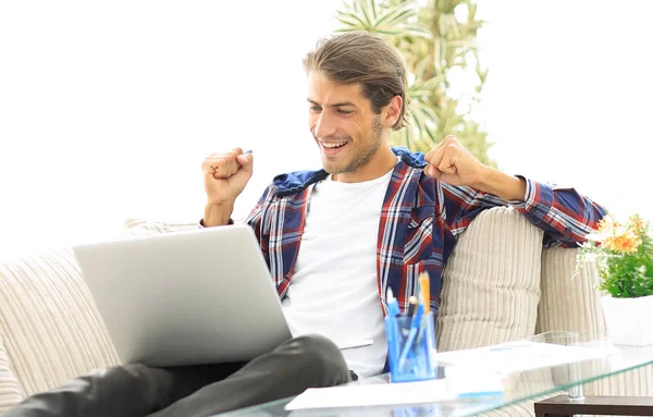 Szczęśliwy młody mężczyzna pracujący z laptopa z domu. — Zdjęcie stockowe