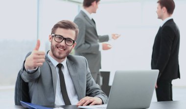 yakışıklı genç iş adamı office toplantısında arka planda insanlarla. başparmak gösterilmesini