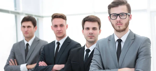 Equipe de negócios confiante em pé na frente de uma janela brilhante — Fotografia de Stock