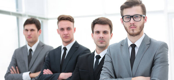 Confident business team standing in front of a bright window