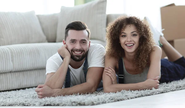 Pareja feliz yace en el suelo en un nuevo apartamento —  Fotos de Stock