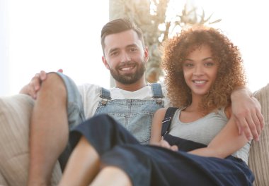 Genç çift kanepede oturan iş elbiseleri