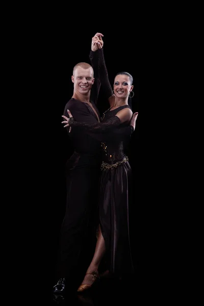 Beautiful couple of professional artists dancing isolated on black — Stock Photo, Image