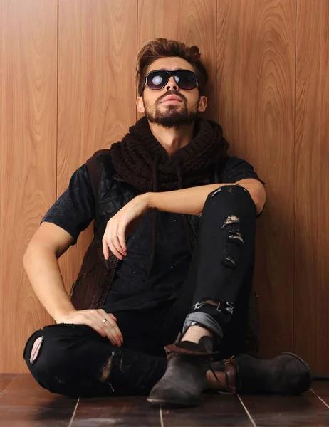 Случайный молодой человек с бородой сидит на полу — стоковое фото