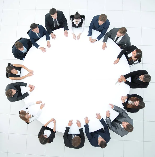 Treinador lidera a sessão com a equipe de negócios sentada em uma mesa redonda . — Fotografia de Stock