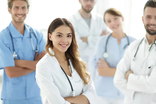 Attractive female doctor with medical stethoscope in front of medical group — Stock Photo, Image