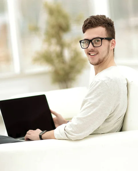 Moderne jonge man aan het werk op laptop zitting in de woonkamer. — Stockfoto