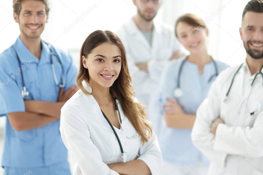 Attractive female doctor with medical stethoscope in front of medical group