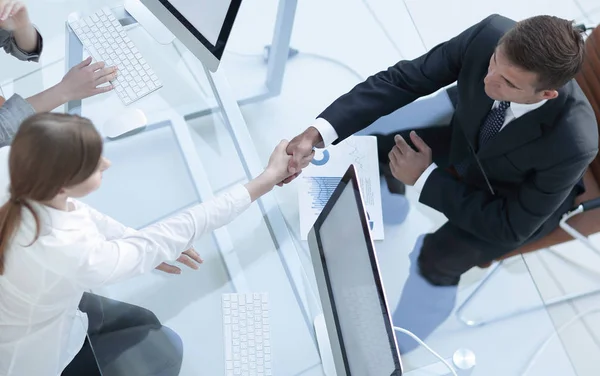 Vista desde la parte superior. apretón de manos el gerente superior y el empleado por encima del escritorio — Foto de Stock