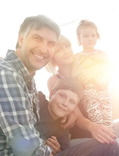 Famiglia con due bambini seduti insieme e guardando la fotocamera — Foto Stock