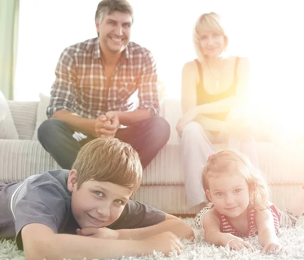 Retrato de família feliz sentados juntos na sala de estar — Fotografia de Stock