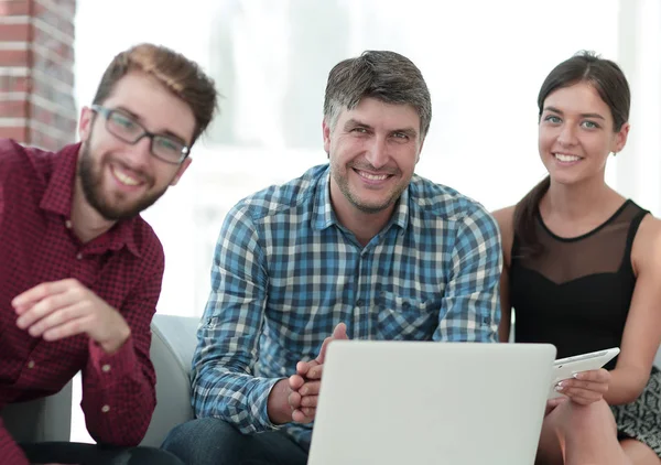 Grupp unga kollegor som använder bärbar dator på kontoret — Stockfoto