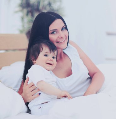 Anne ve bebek bezi güneşli yatak odasında oynarken içinde