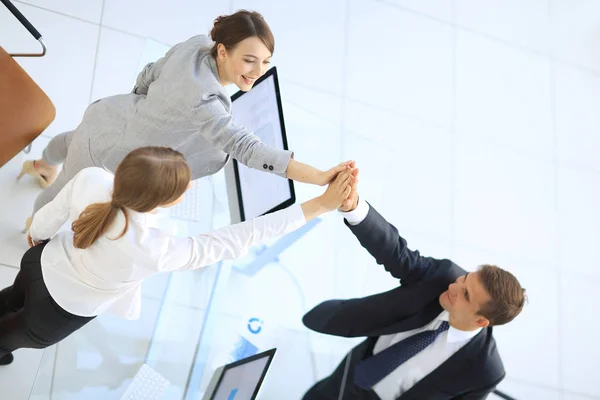 view from the top.members of the business team giving each other a high five above the Desk.