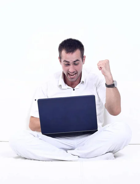 Homem feliz trabalhando no laptop, sentado no sofá . — Fotografia de Stock