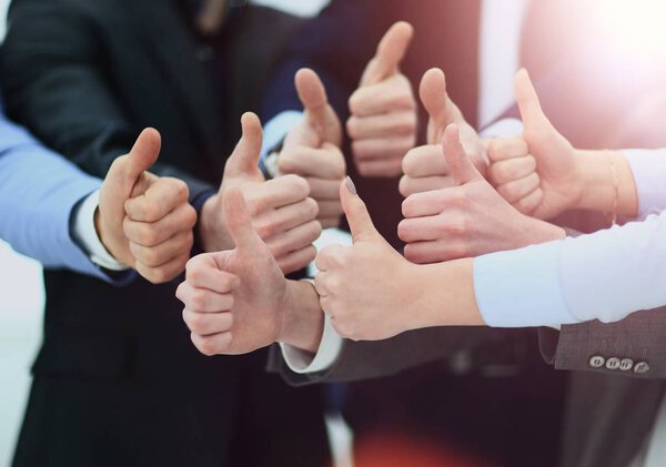 Cheering business people holding many thumbs thumbs up