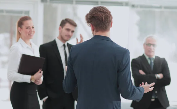 Uomo d'affari di successo in piedi con il suo personale in background a — Foto Stock