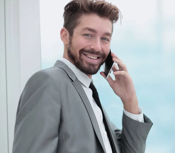 Schöner Geschäftsmann im Büro mit Smartphone — Stockfoto