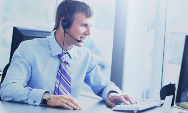 kulaklık kullanarak callcenter çalışma mutlu genç adam