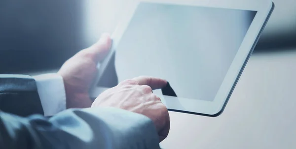 Businessman uses the tablet in a modern office — Stock Photo, Image