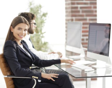 Masa başında oturan genç iş kadını