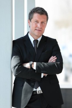 office penceresinde yakınındaki ayakta ciddi iş adamı.